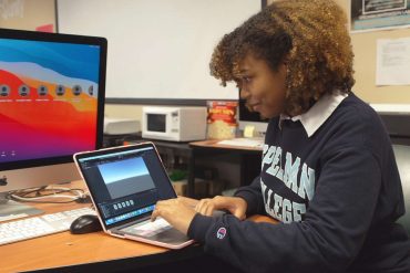 Spellman student Madeline Brown showing a game that she's developing on her laptop.